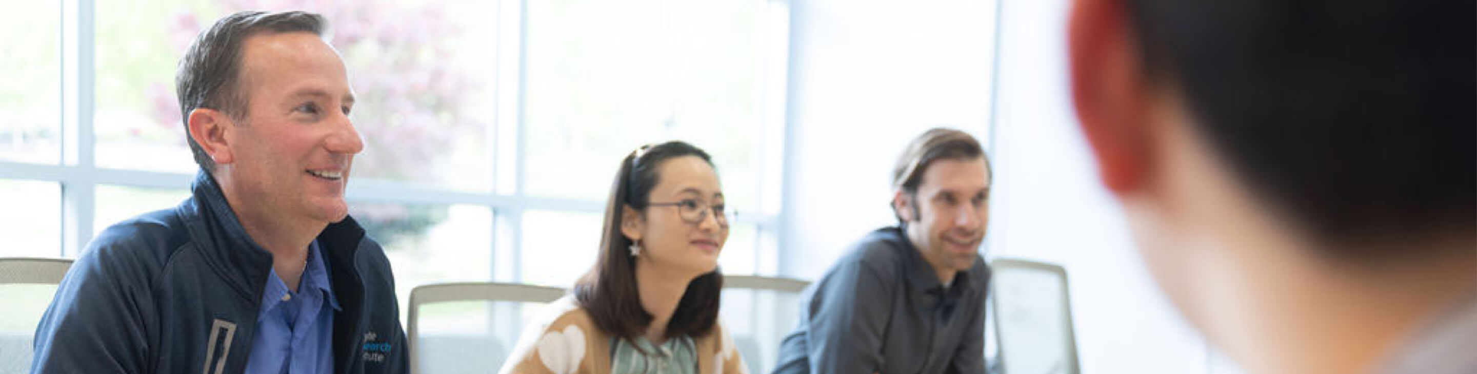 Group of people sitting around a conference table and talking